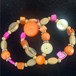 Pink, orange, and gold tone wood and plastic beaded elastic band bracelet